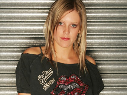 Cally Gage, standing outside what looks suspiciously like Ed Real's lock-up